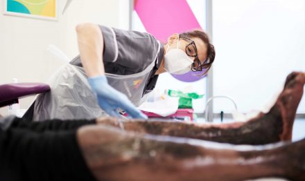 Clinician treating patient with a leg ulcer at the Acclerate centre for exellence in Hackney, London